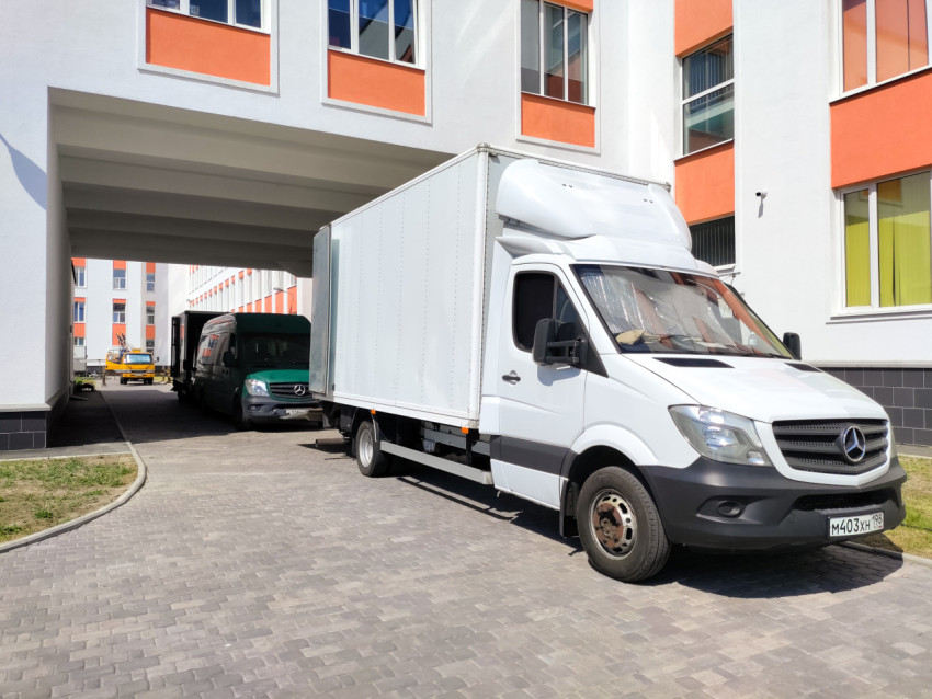 Коммерческие фургоны съёмочной группы под аркой жилого комплекса