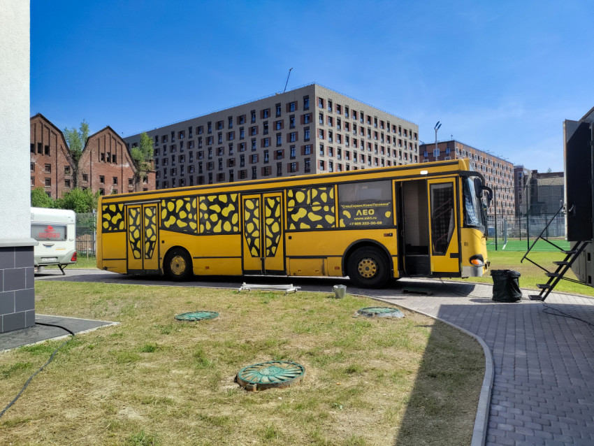 Длинный сервисный автобус съёмочной группы в жилом квартале