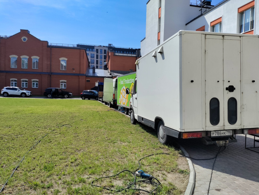 Фургоны и транспорт съёмочной группы возле здания