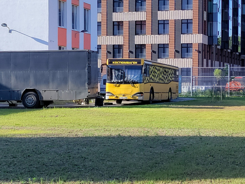 Автобус-костюмоваген рядом с техническим фургоном во дворе жилого комплекса