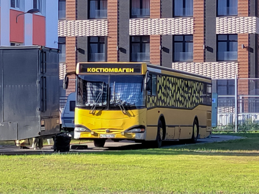 Яркий автобус-костюмоваген возле жилого комплекса