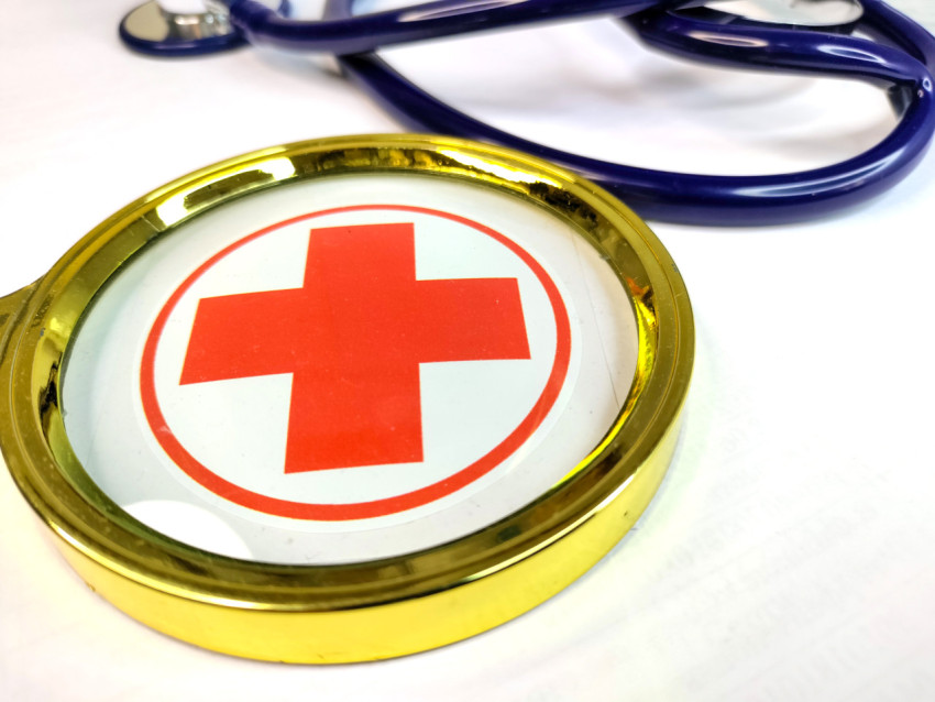 Медицинский знак под увеличительным стеклом и стетоскоп