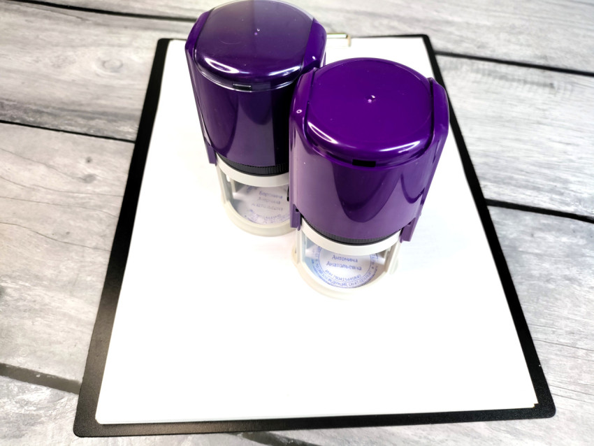 Два автоматических штампа на планшете с документами