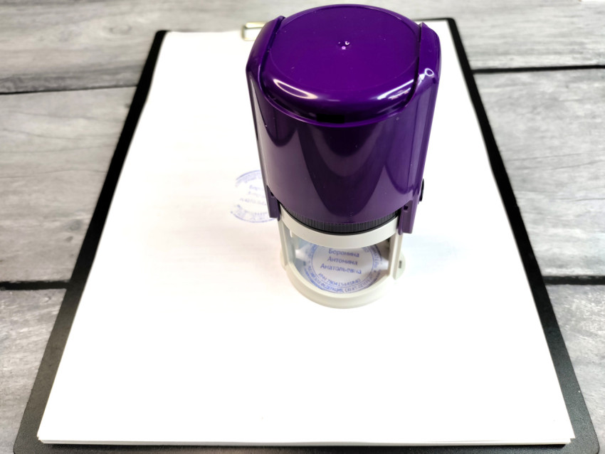 Автоматический штамп с круглой печатью на документе