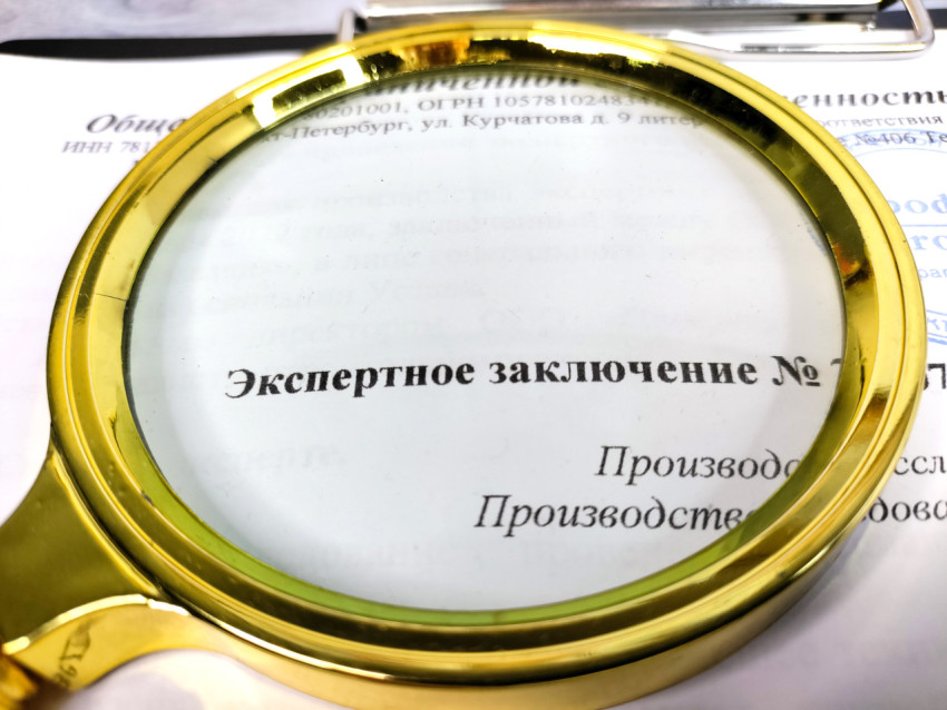 Лупа на бланке с текстом экспертного заключения