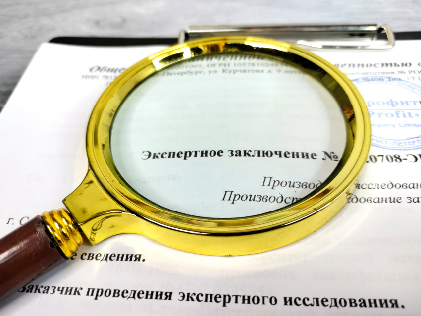 Лупа над текстом экспертного заключения на официальном бланке