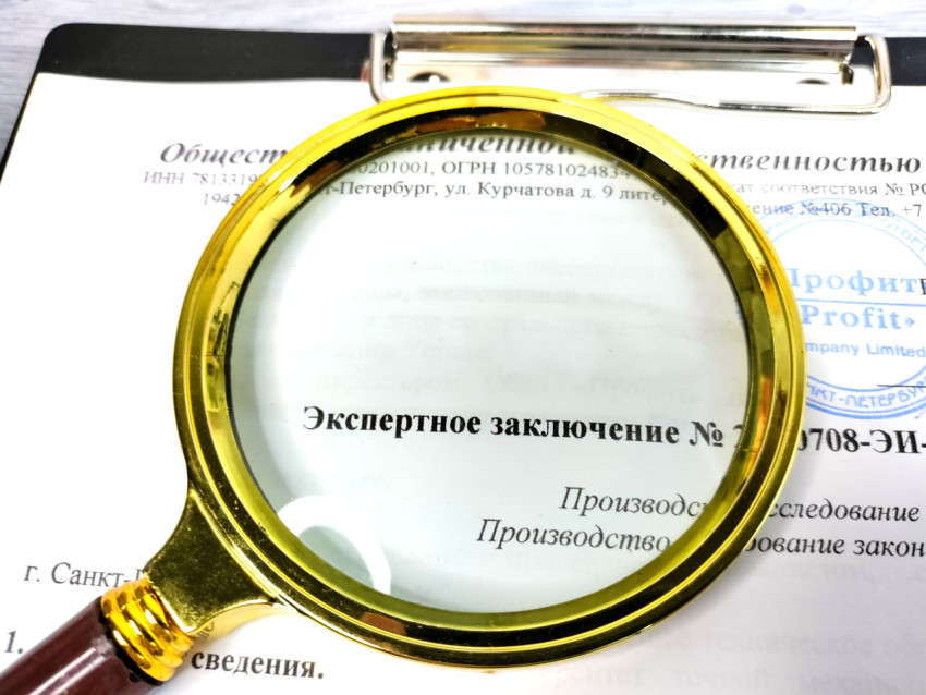 Лупа на экспертном заключении с реквизитами организации