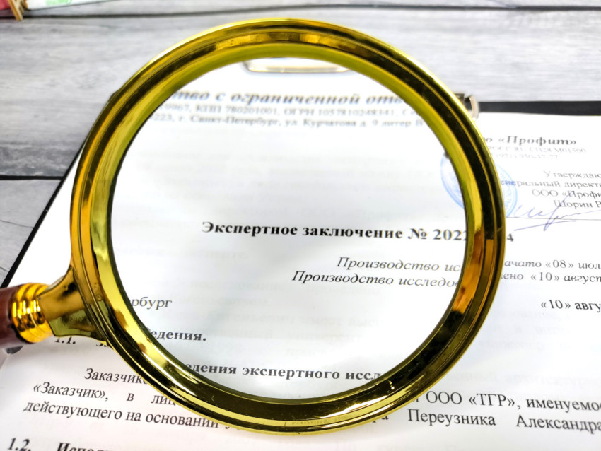 Лупа над текстом экспертного заключения с подписью и печатью