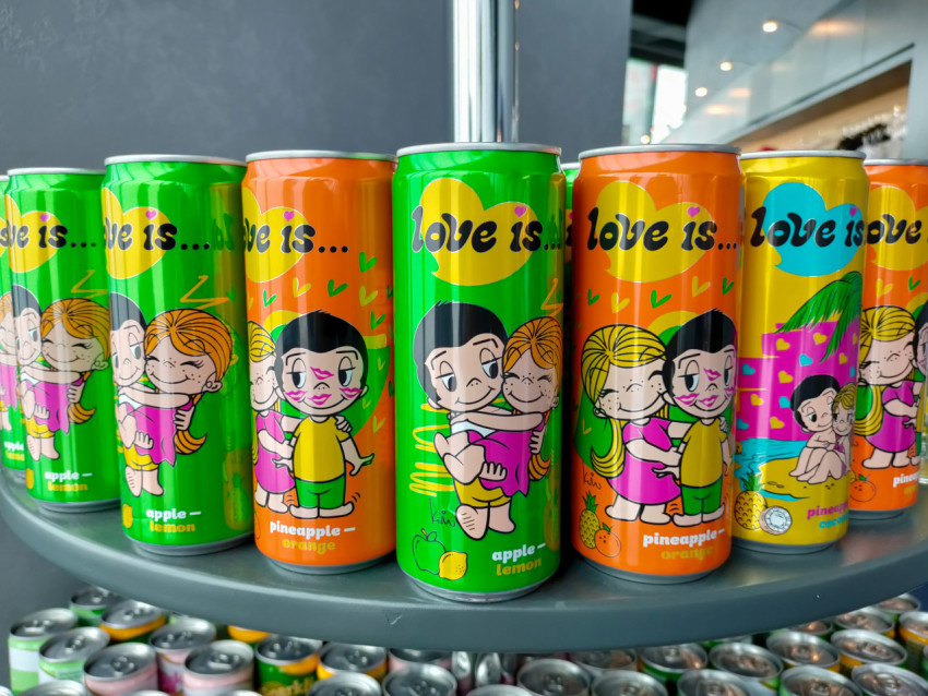 Банки напитков Love Is с иллюстрациями на витрине