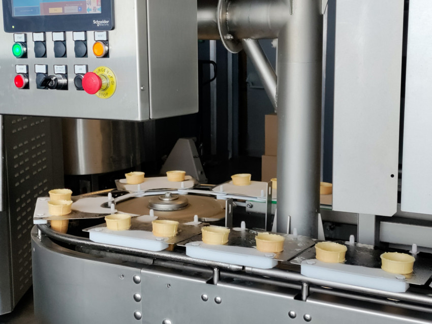 Конвейер с вафельными стаканчиками перед фасовкой мороженого