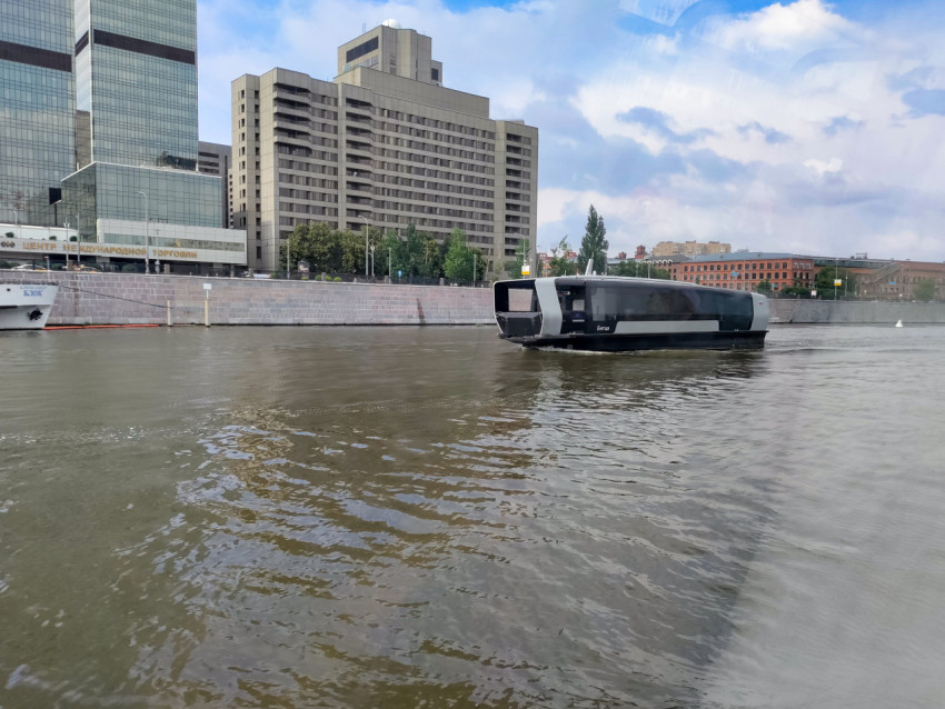 Пассажирское электросудно на фоне офисной застройки Москвы