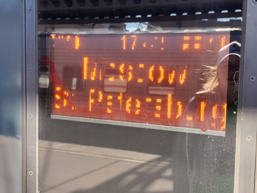 Электронное табло с информацией о поезде на платформе вокзала