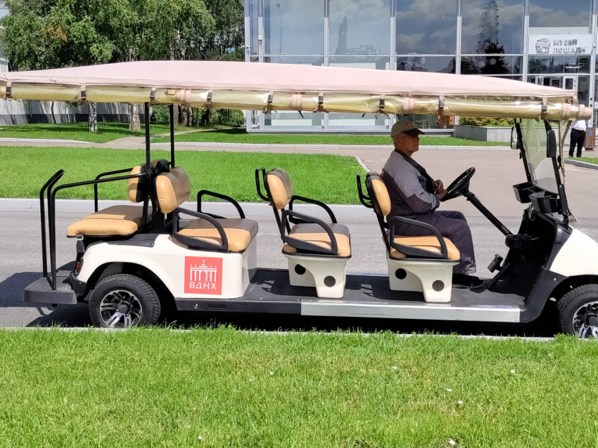 Экскурсионный электрокар ВДНХ на фоне павильона