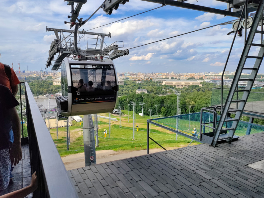 Кабина канатной дороги над зелёными склонами Воробьёвых гор