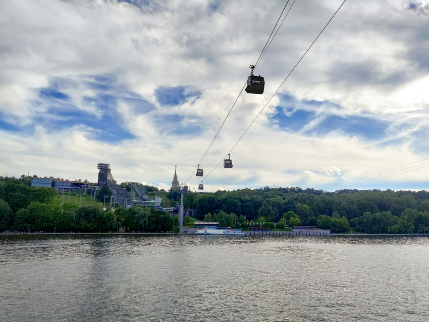 Линия канатной дороги на фоне Воробьёвых гор и Москвы-реки