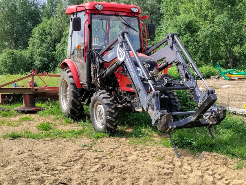 Фронтальный погрузчик на тракторе, вид спереди с гидравлическими шлангами