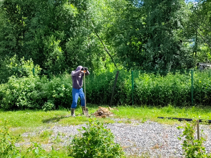 Рабочий на площадке свайного фундамента у ограждения с подготовленными материалами