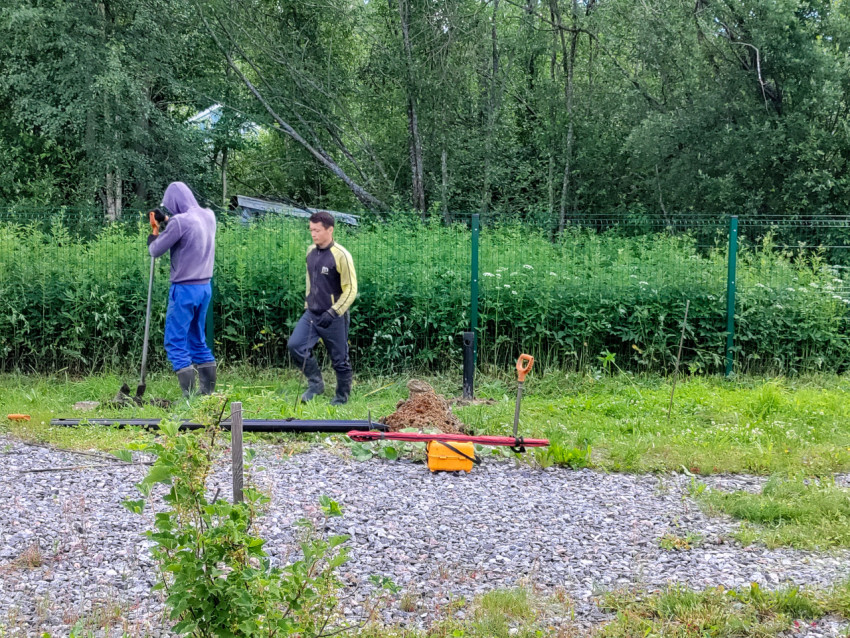 Подготовка отверстия и установка сваи под свайный фундамент рядом с инструментами на земле