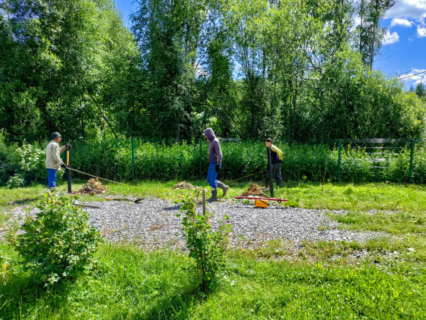 Рабочие измеряют шаг установки винтовых свай при устройстве свайного фундамента
