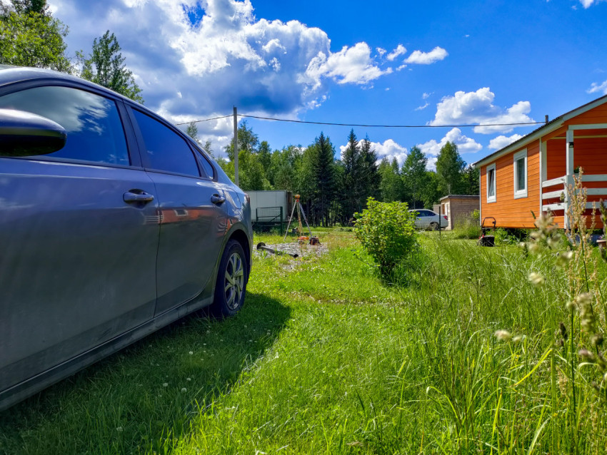 Тренога геодезического прибора для разметки свайного фундамента рядом с дачным домом