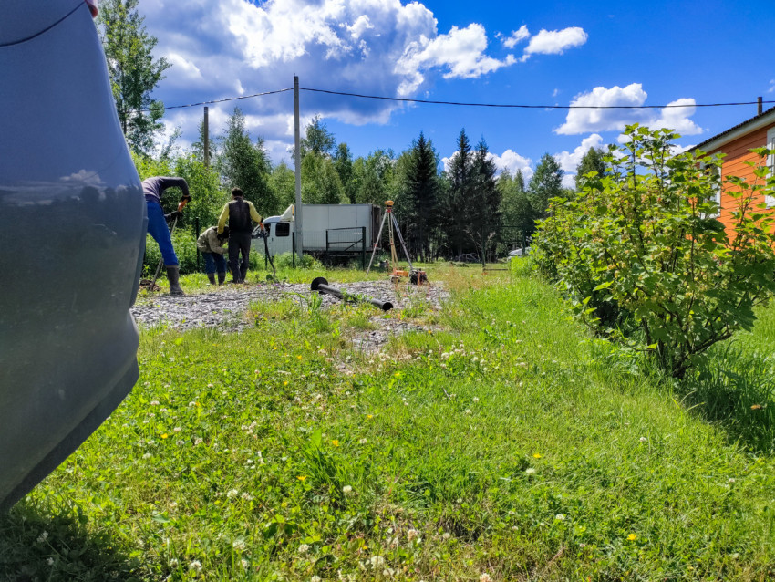 Бригада подготавливает площадку и элементы для монтажа свайного фундамента у дома