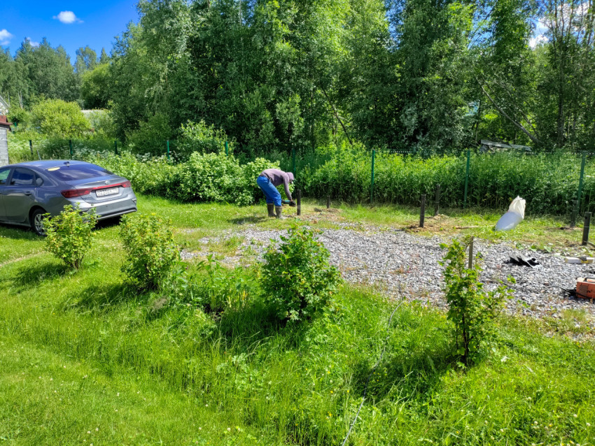 Общий вид монтажа свайного фундамента на участке с щебёночной площадкой и ограждением