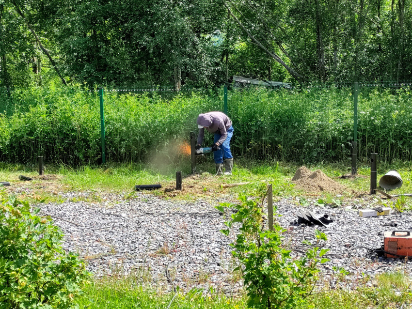 Резка металлической сваи болгаркой при устройстве свайного фундамента на участке
