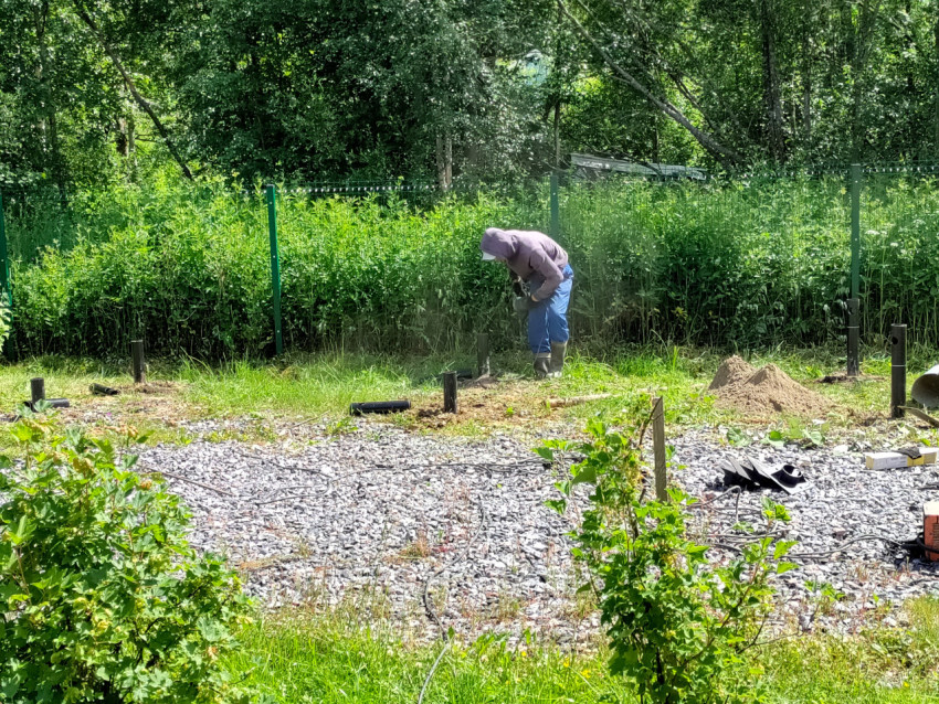 Рабочий у металлической сваи после резки на участке устройства свайного фундамента