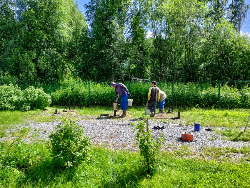 Рабочие выверяют и подготавливают точки установки винтовых свай свайного фундамента