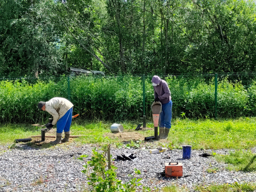 Подсыпка материала в винтовую сваю через воронку при устройстве свайного фундамента