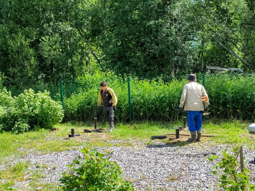 Размеченное свайное поле с установленными винтовыми сваями и рабочими на площадке