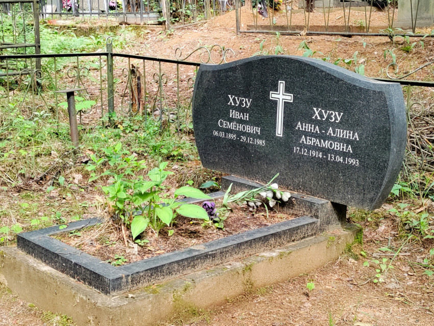 Гранитное семейное надгробие с православным крестом в ограждённом участке кладбища