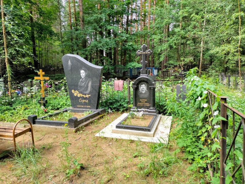 Две гранитные могилы с православным крестом на лесном кладбище