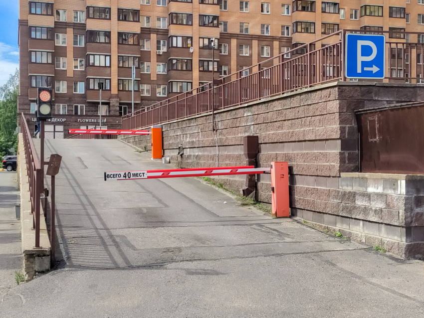 Парковочный въезд с ограничением мест, знаком «P» и барьерной системой на подъёмном проезде