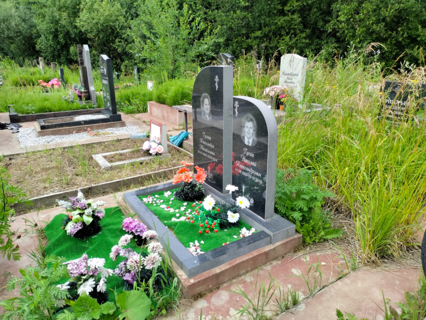 Два вертикальных надгробия Гусевых с портретами на участке с зелёным газонным покрытием