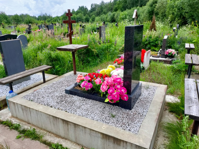 Гранитный надгробный памятник с цветником и бетонным цоколем на кладбище