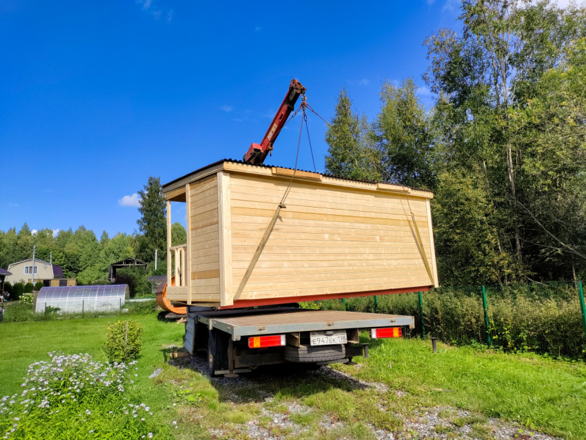 Деревянный модуль с входным проёмом перемещают краном-манипулятором на загородном участке