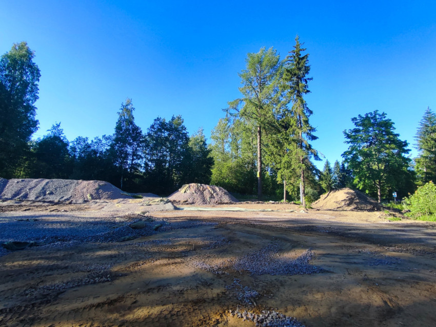 Песок и щебень в насыпях на строительной площадке у лесного массива