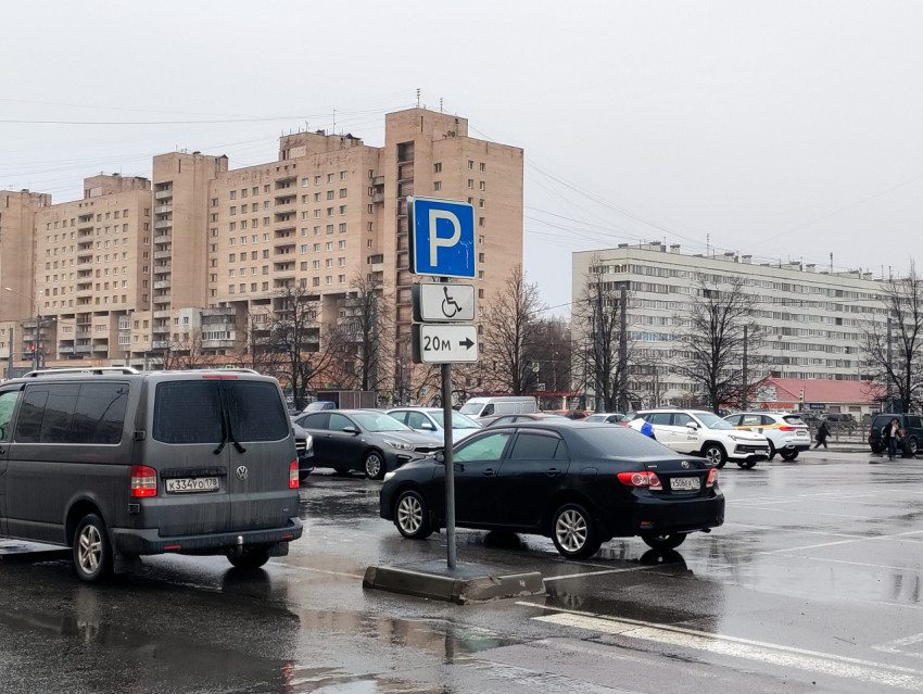Знак парковки для маломобильных водителей на фоне жилой застройки