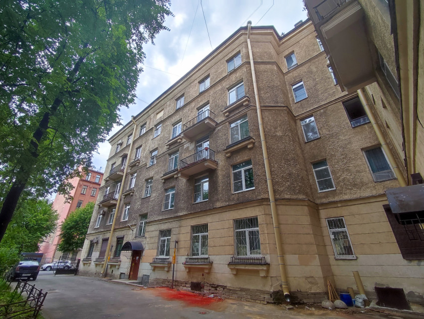 Фасад пятиэтажного жилого дома с балконами во дворе