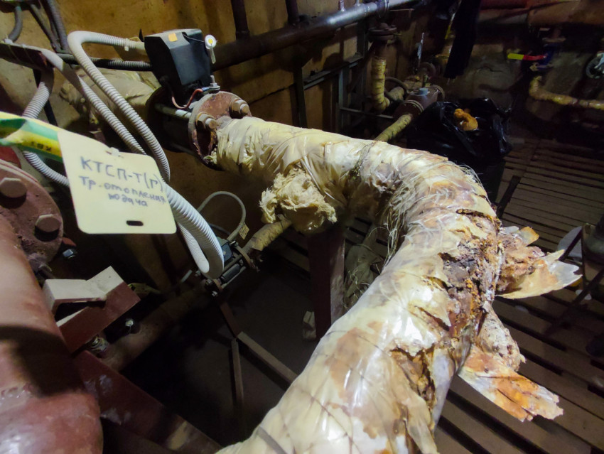 Корродированный поворот трубопровода отопления с электроприводом в техническом подвале