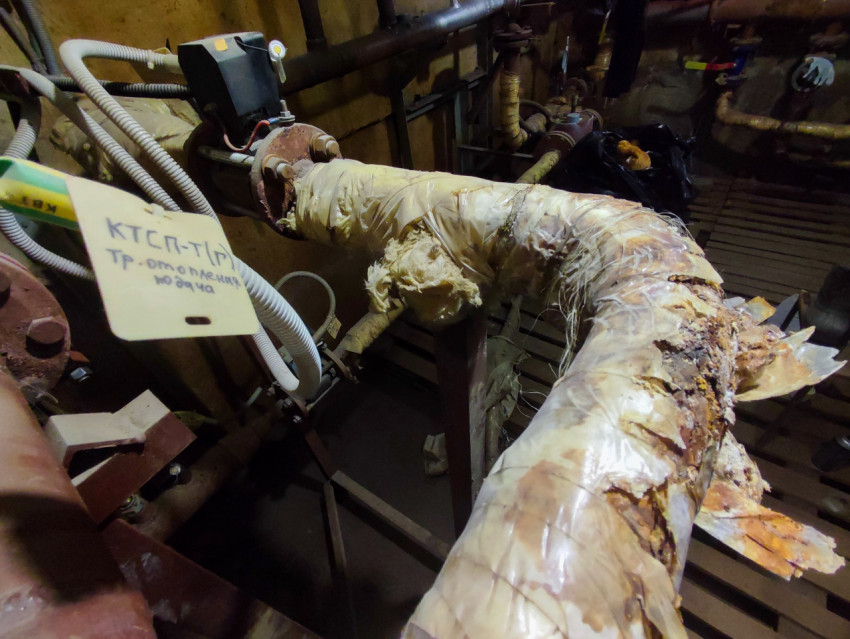 Подающий трубопровод отопления с разорванной теплоизоляцией и маркировочной биркой