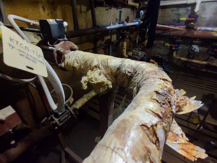 Тепловой узел в подвале с трубной разводкой, кранами и корродированным участком магистрали