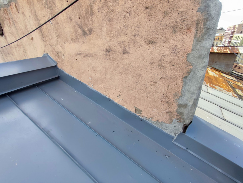 Примыкание металлической кровли к оштукатуренной стене с кабелем и кровельным фартуком