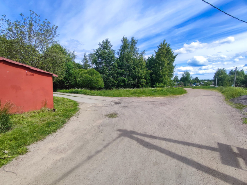 Перекрёсток грунтовых дорог рядом с красным хозяйственным строением