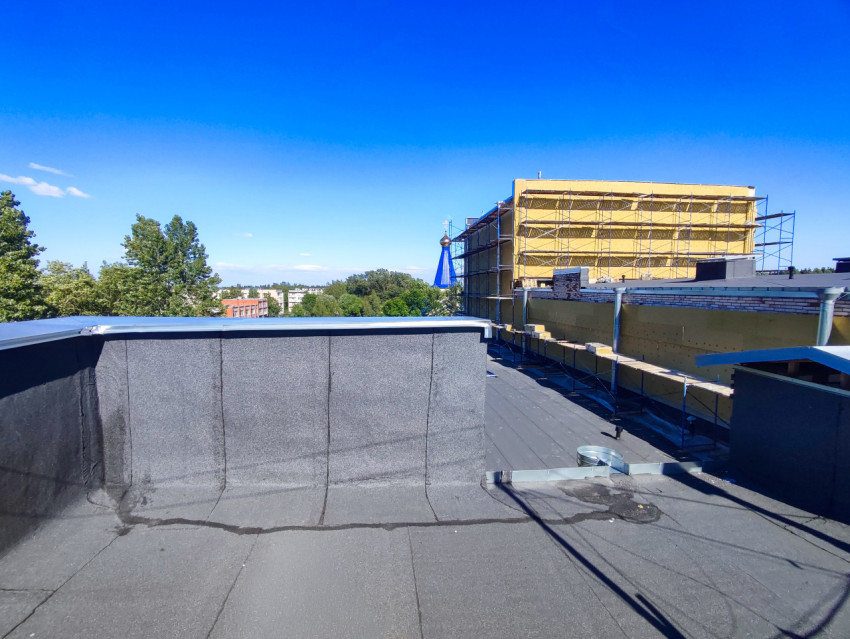 Плоская крыша с битумной гидроизоляцией и утепляемым фасадом в строительных лесах