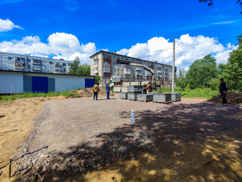 Разгрузка тротуарной плитки краном-манипулятором на дворовой стройплощадке