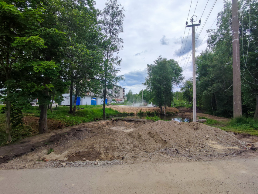 Земляные работы у дороги рядом с лесом и линией электропередачи