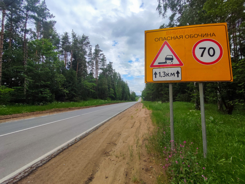 Крупный план дорожного щита «Опасная обочина» с ограничением скорости 70