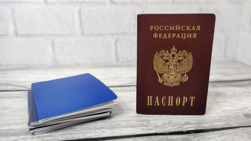 Паспорт России и синие документы на деревянной поверхности